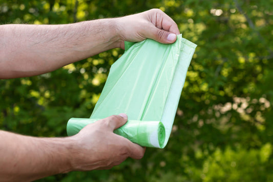 Man holding eco plastic bio bag in roll outdoors