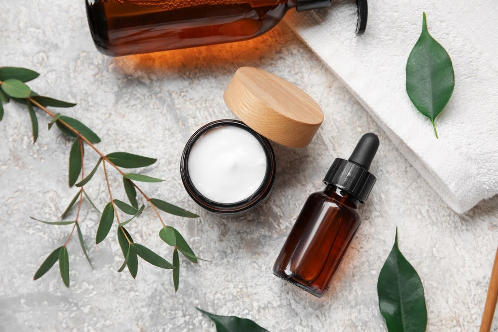 Clean beauty products—natural oil, soap, face cream, and a towel displayed together.