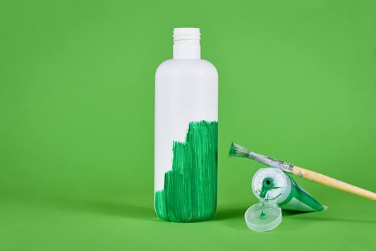 How to spot greenwashing: a white plastic bottle being painted green.