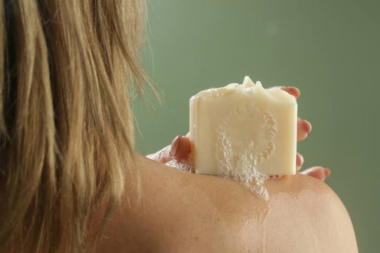 Zero-waste shower routine: a woman using natural bar soap.