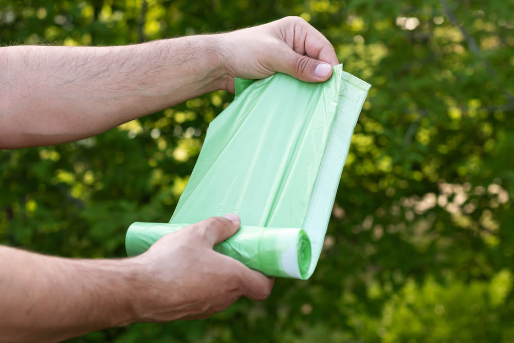 Man holding eco plastic bio bag in roll outdoors 